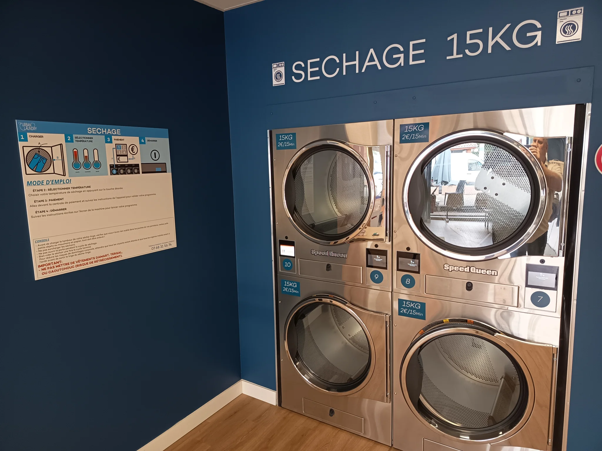 Quatre sèche-linge Speed Queen de 15 kg sous le panneau Séchage 15KG